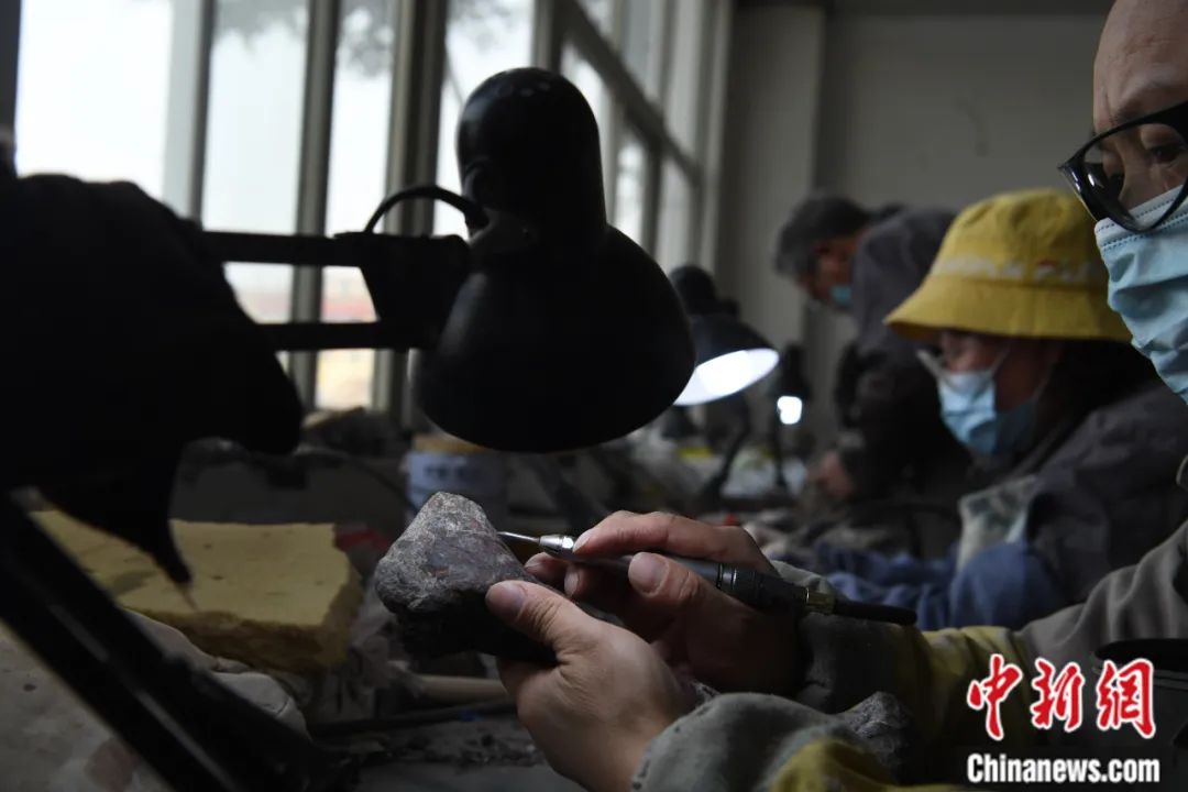 重庆市地质遗迹保护与研究实验室化石修复中心，工作人员正在对元始巴山龙化石进行修复。中新社记者 陈超摄