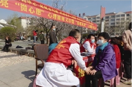 志愿者在给市民做心理健康辅导。丹东市文明办供图
