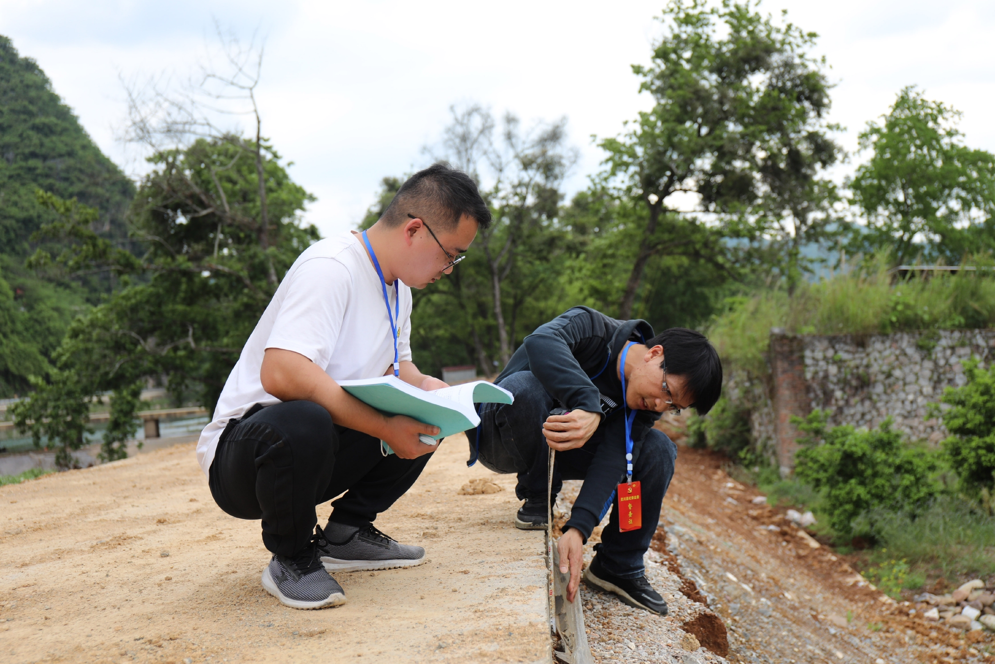 图为灵川县纪委监委派驻县住房和城乡建设局纪检监察组到项目现场测量水泥路面厚度。