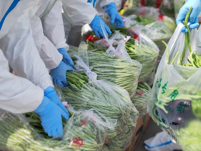 ▲4月11日，大连万众应急救援队的志愿者们组成一条爱心蔬菜打包“流水线”。 受访者供图