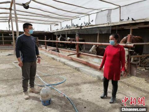 新疆商务厅“访惠聚”驻村工作队队长宋维程与村养殖大户交流增收做法。 朱景朝 摄