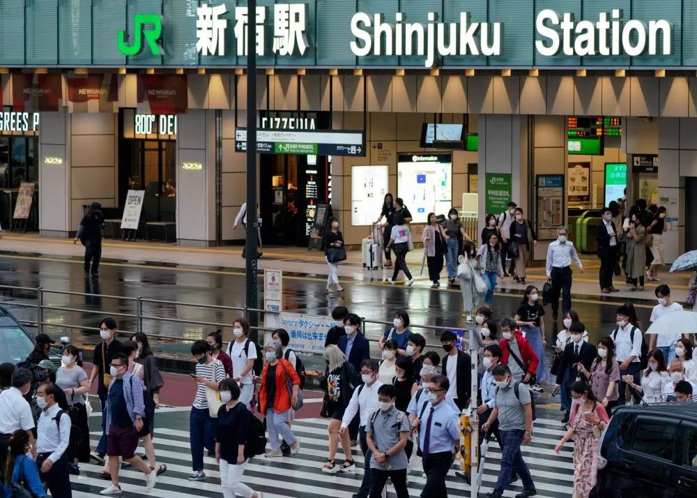 7月8日，人们戴着口罩在日本东京新宿车站附近出行。（新华社发，克里斯托弗·朱摄）