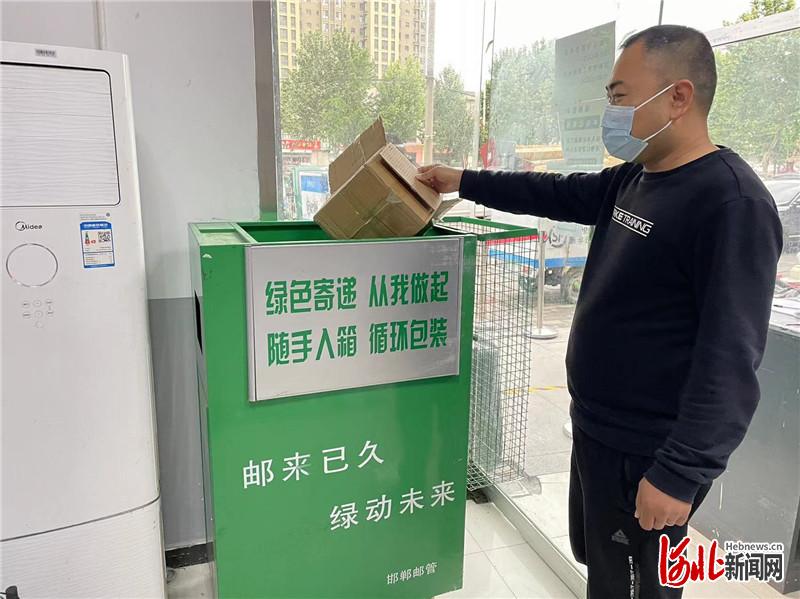 在邯郸市保利花园顺丰快递业务部，居民正在把不用的纸箱子放进快递包装二次回收箱。河北日报通讯员李阳摄