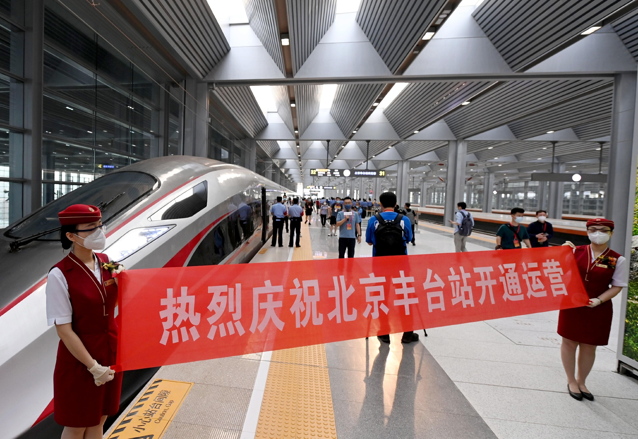 北京丰台站站台上，乘务员拉起横幅庆祝北京丰台站开通运营。董芳忠/摄
