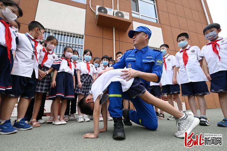 2022年6月28日,在河北省邯郸市邯山区滏河学校,邯郸蓝天救援队的队员为学生们讲解防溺水急救技能。通讯员郝群英摄