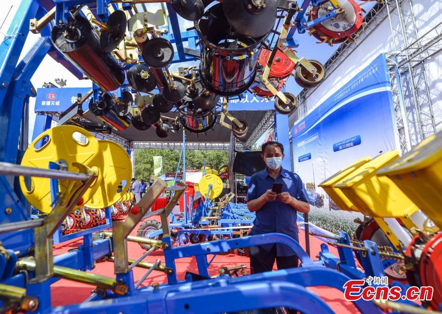 <p>Visitors take a close look on a cotton picker during the 2022 agricultural machinery expo in Urumqi, capital of northwest China's Xinjiang Uyghur Autonomous Region, July 3, 2022. (Photo: China News Service/Liu Xin)</p>
