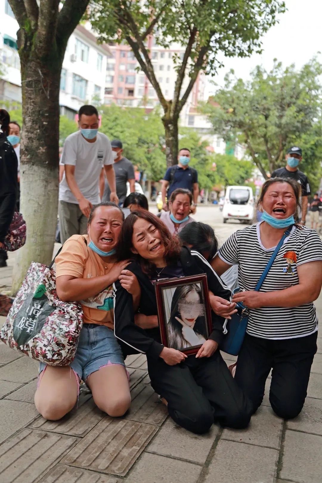 2020年8月,嫌疑人刚被抓获不久,李倩月的亲属在勐海县,李倩月母亲抱着女儿的相片(张雷 摄)