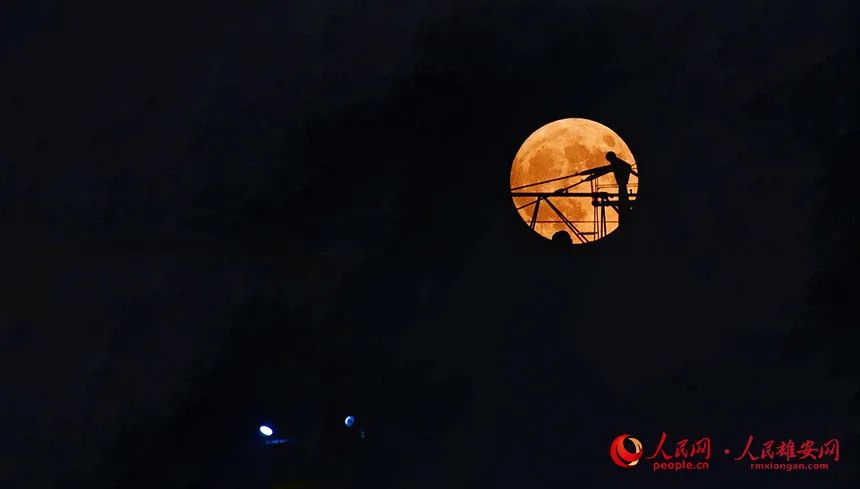 “超级月亮”映衬着雄安建设者忙碌的身影。杨亚文摄