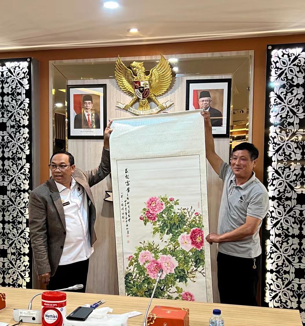 (图为《满堂富贵》创作者华建军老师与印尼人民代表议会(国会)长RAHMAN HADI.M.SI赠礼留影)