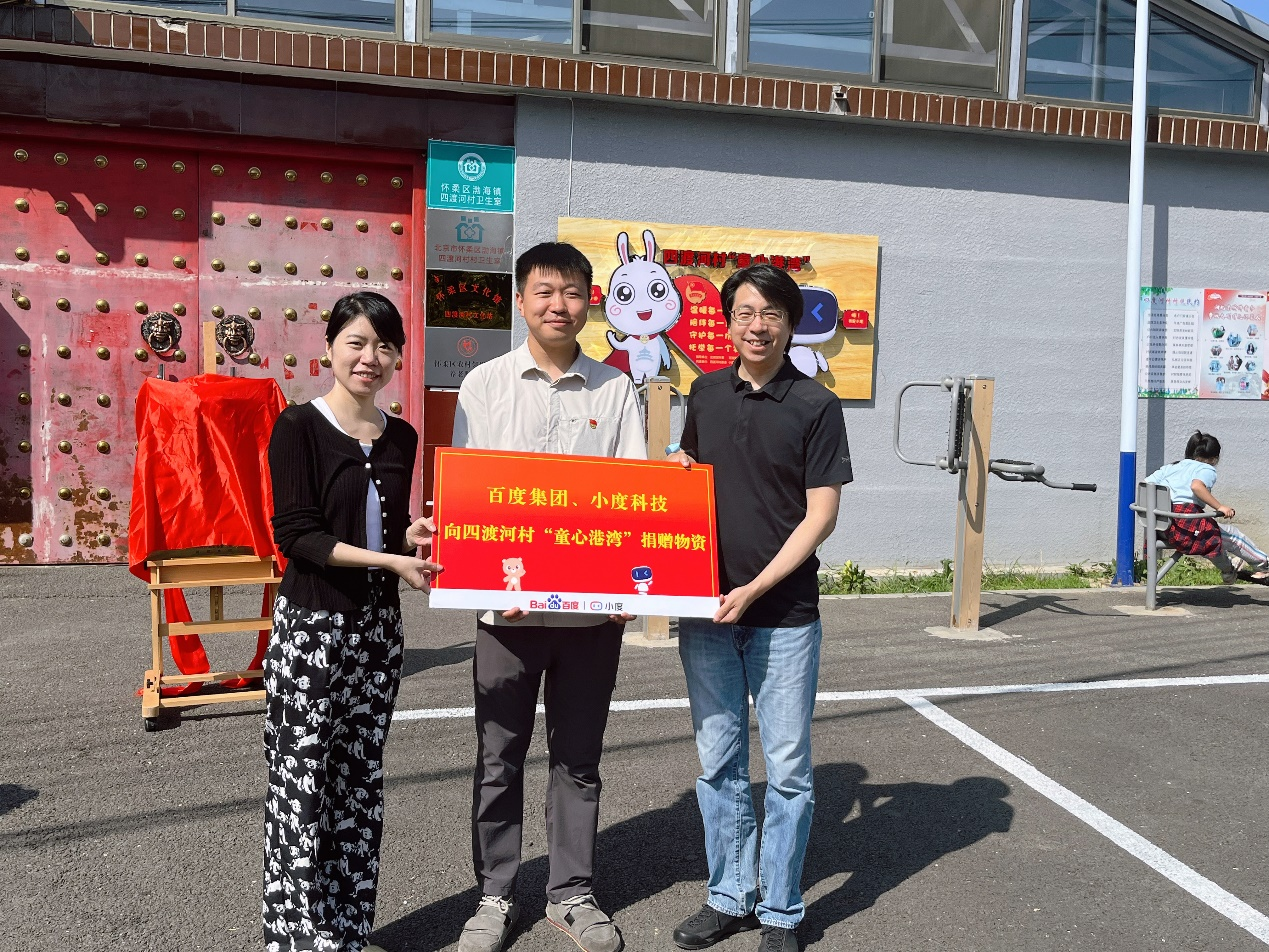 (图:小度科技财务副总裁毕姗姗与法律研究中心兼业务监察部总经理陈晨向四渡河村村委会捐赠物资)