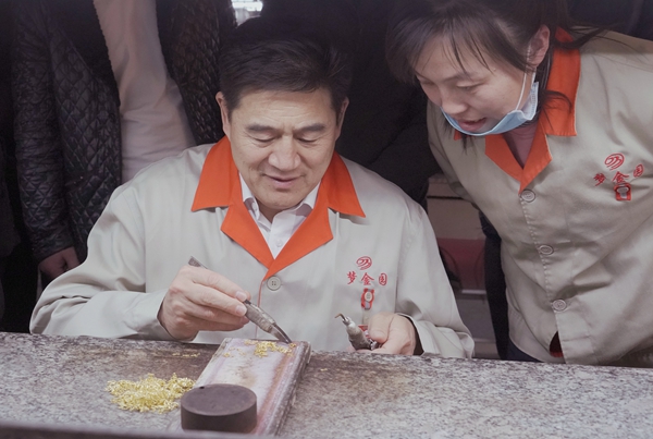 王忠善(左)向徒弟传授金银细工制作技艺
