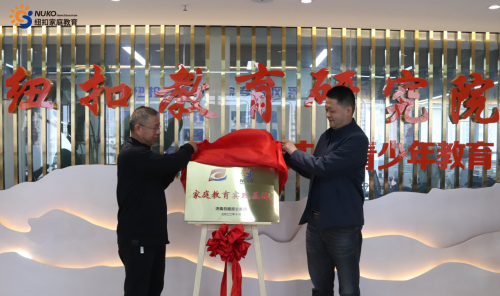 图为:山东省心理卫生协会会长易继湖(左)、济南日报报业集团教育产业项目部主任姚长松(右)共同为“家庭教育实践基地”揭牌