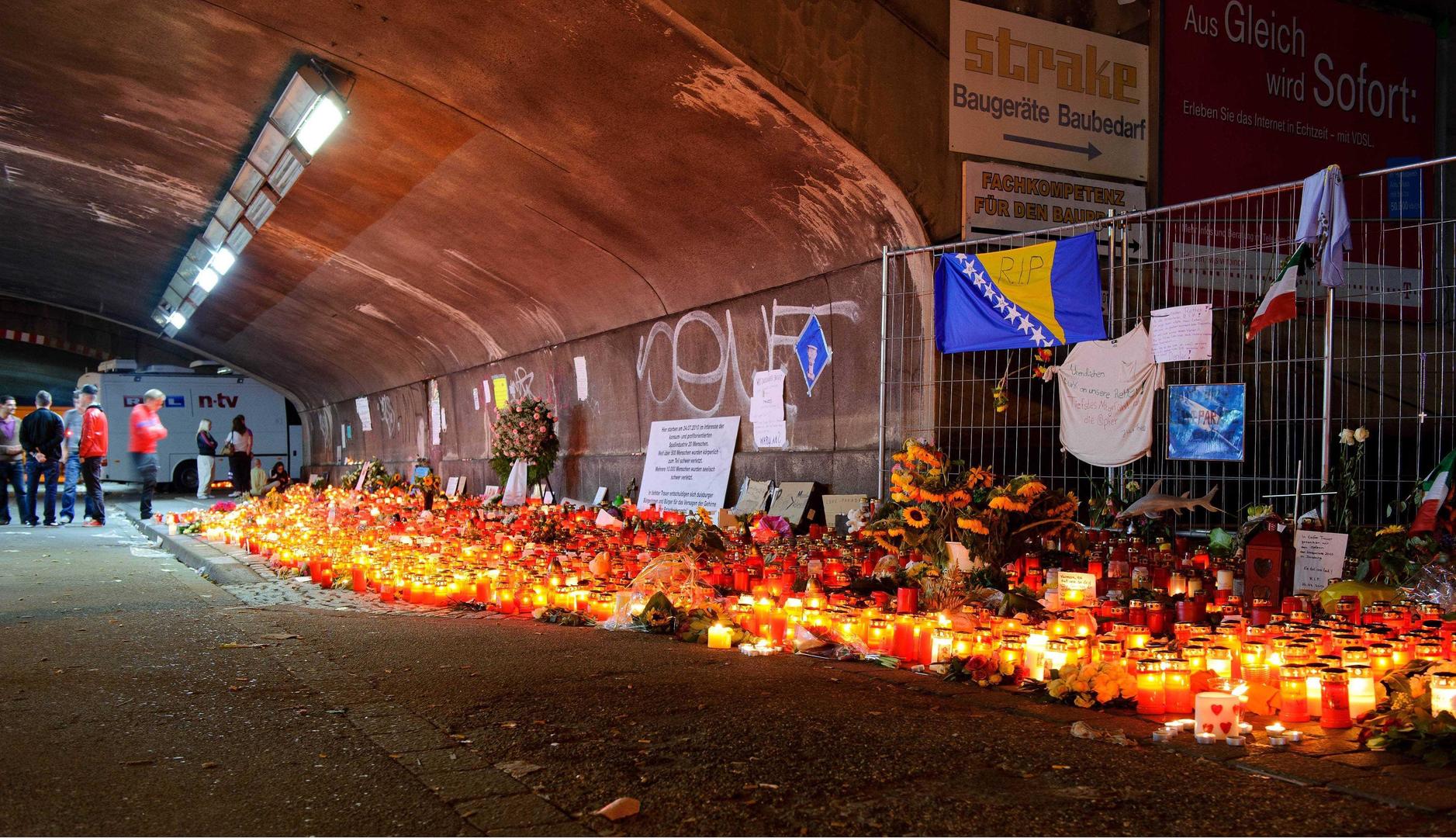 ↑2010年7月28日，德国杜伊斯堡，民众为踩踏事故遇难者献上鲜花和蜡烛表示哀悼。图据视觉中国