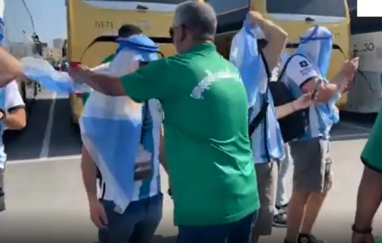 沙特球迷为阿根廷球迷佩戴头巾（阿拉伯卫星电视台截图）
