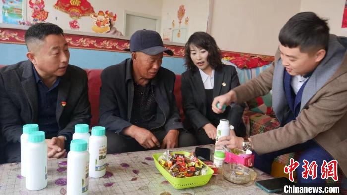 图为杨新年(左一)为农户送去微生物肥料。张林虎 摄