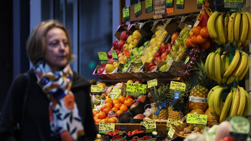 11月7日，一名女子走过法国巴黎路边一个水果店。 新华社记者高静 摄