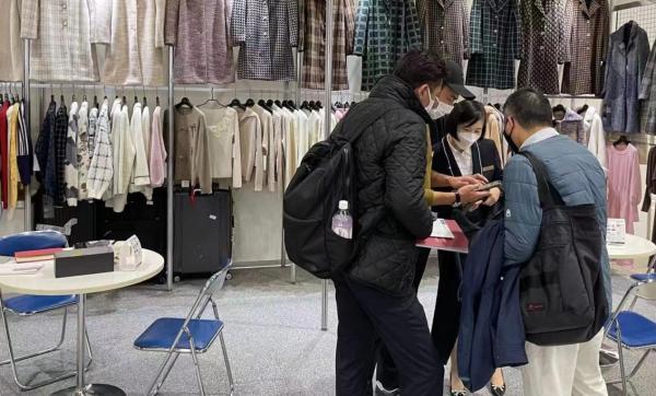 2022年12月,来自浙江省嘉兴市的服饰企业在2022年亚洲纺织成衣展(AFF)上与客户沟通。受访者供图