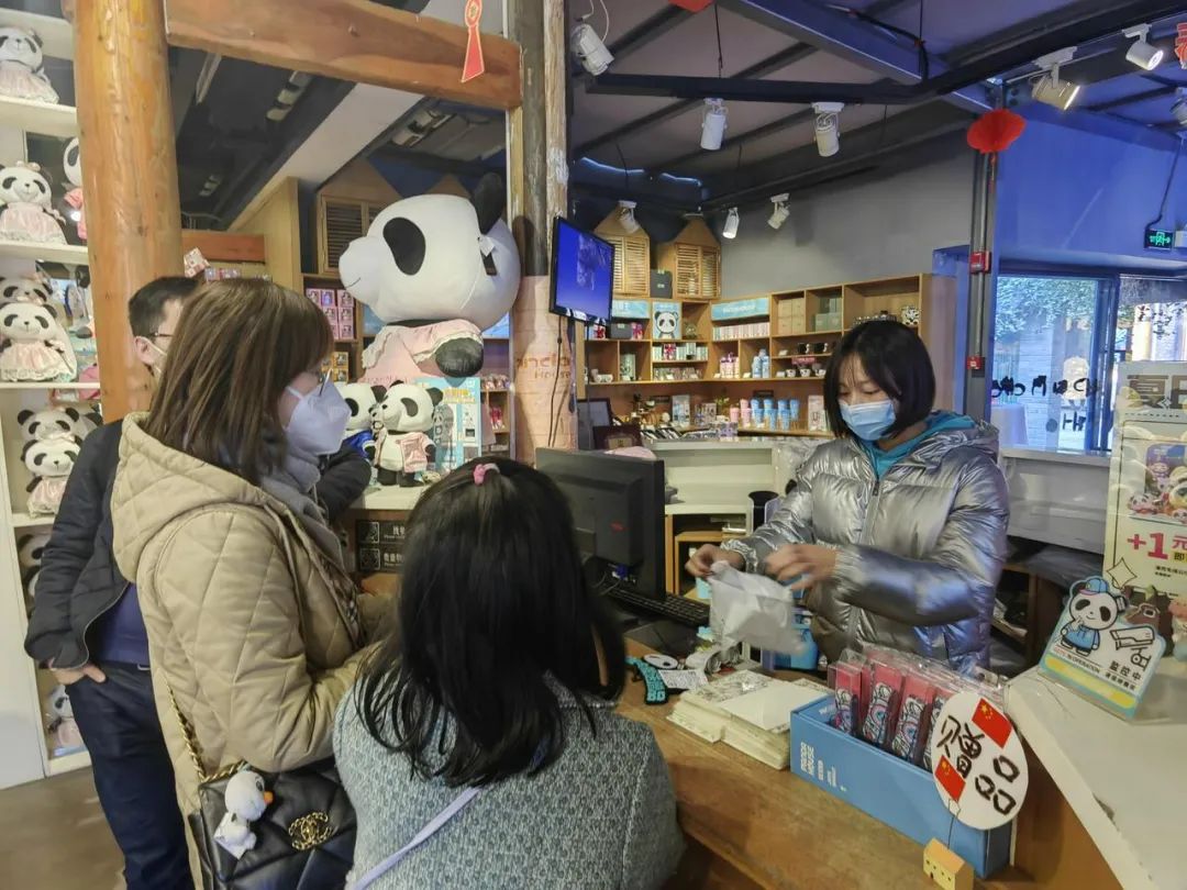 1月5日，四川成都宽窄巷子熊猫屋店长徐小清（右）在给顾客结账。本报记者董小红 摄