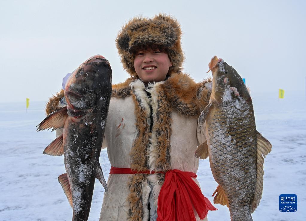 2023年1月7日，在新疆福海县第十六届乌伦古湖冬捕文化旅游节上，渔工展示捕到的鱼。新华社记者 李响 摄