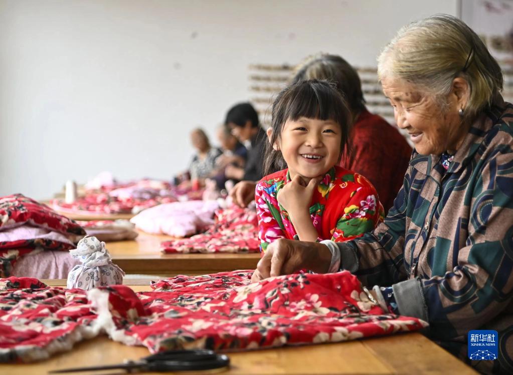 在山东沂水县吴家楼子村，一名老人在教重孙女沂蒙小棉袄的缝制手艺（资料照片）。新华社发 （王文剑 摄）