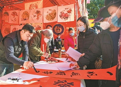 （荔灣花市，書法家現場為市民寫揮春。 廣州日報·新花城記者廖雪明 實習生劉暢攝）