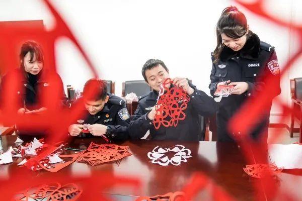 春节值班民警剪窗花布置节日氛围。陆泽昭 摄