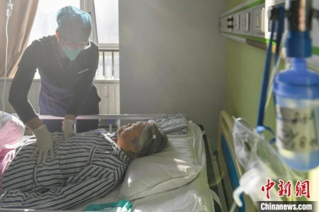图为康复师帮助患者进行呼吸训练。　中新社记者 赵文宇　摄
