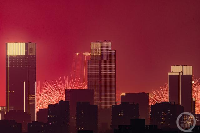 焰火将城市上空染成红色，寓意新年将红红火火。上游拍客 古韬 摄