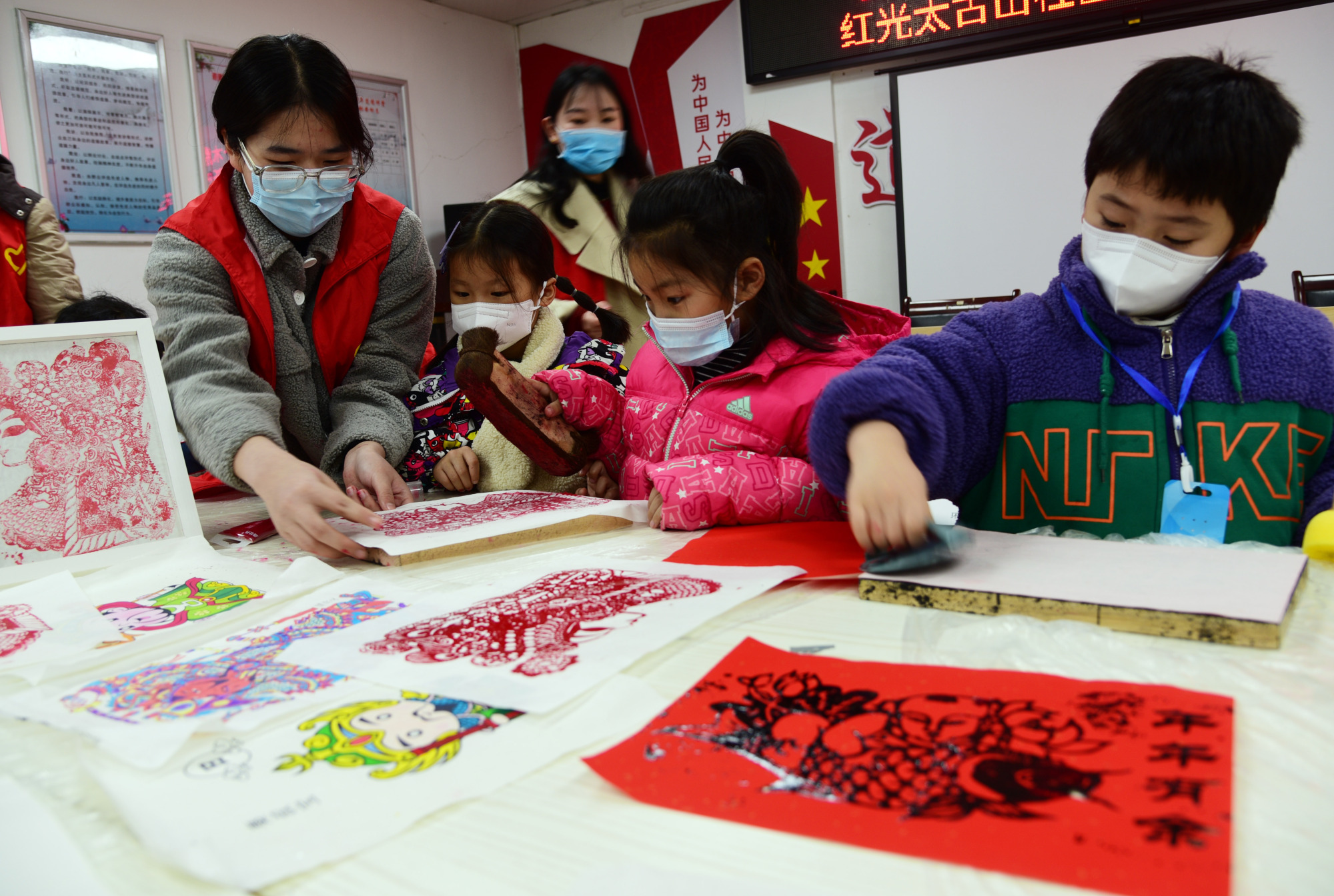 △2023年1月15日,大学志愿者在江苏省镇江市红光太古山社区指导小朋友拓印木版年画。