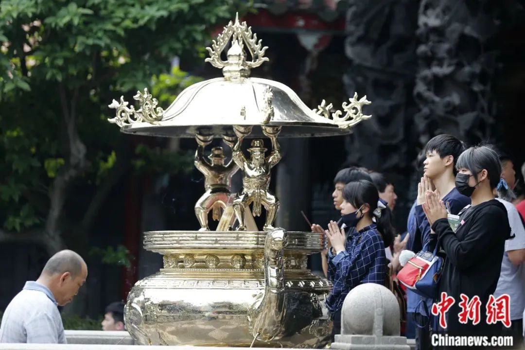 资料图:台北龙山寺内,信众有的持一柱香祈福,有的双手合掌行礼。中新社记者 陈小愿 摄