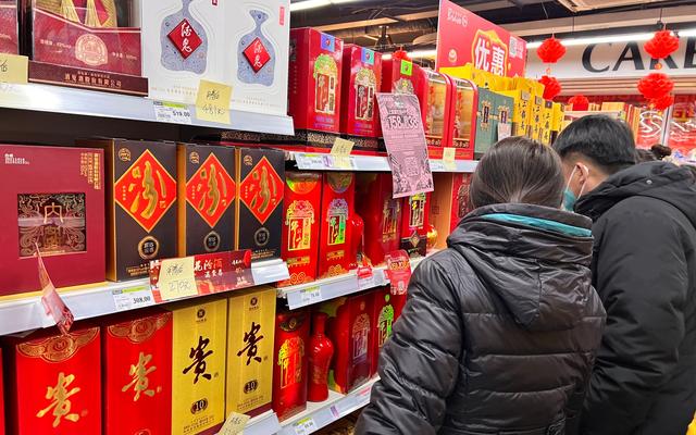 臨近春節,北京的一家超市白酒貨架前不少消費者前來選購。 新京報記者 秦勝南 攝