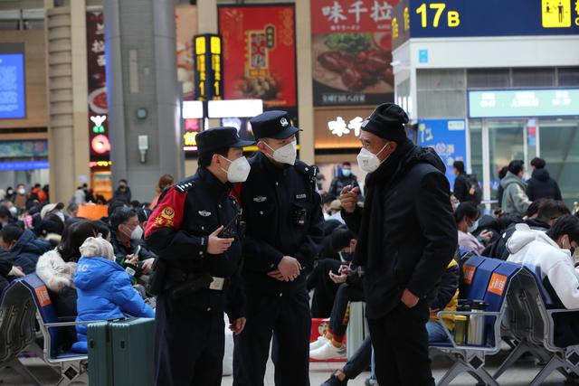 北京南站候车大厅里,民警正在回应乘客的求助。 北京铁警供图