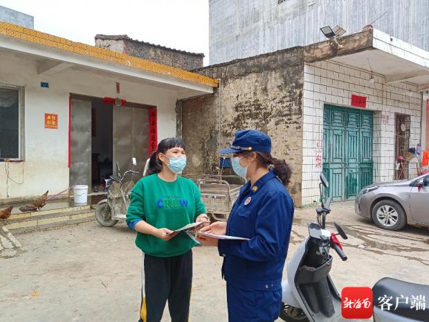 周伟菊向居民派发消防知识宣传资料。图片由洋浦消防提供