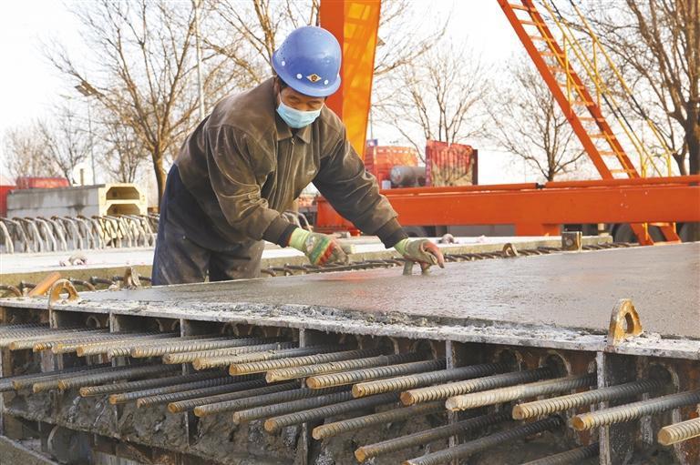 一月三日,在陕西建工新型建材有限公司三号堆场,工人正在进行装配式预制桥面板收面作业。
