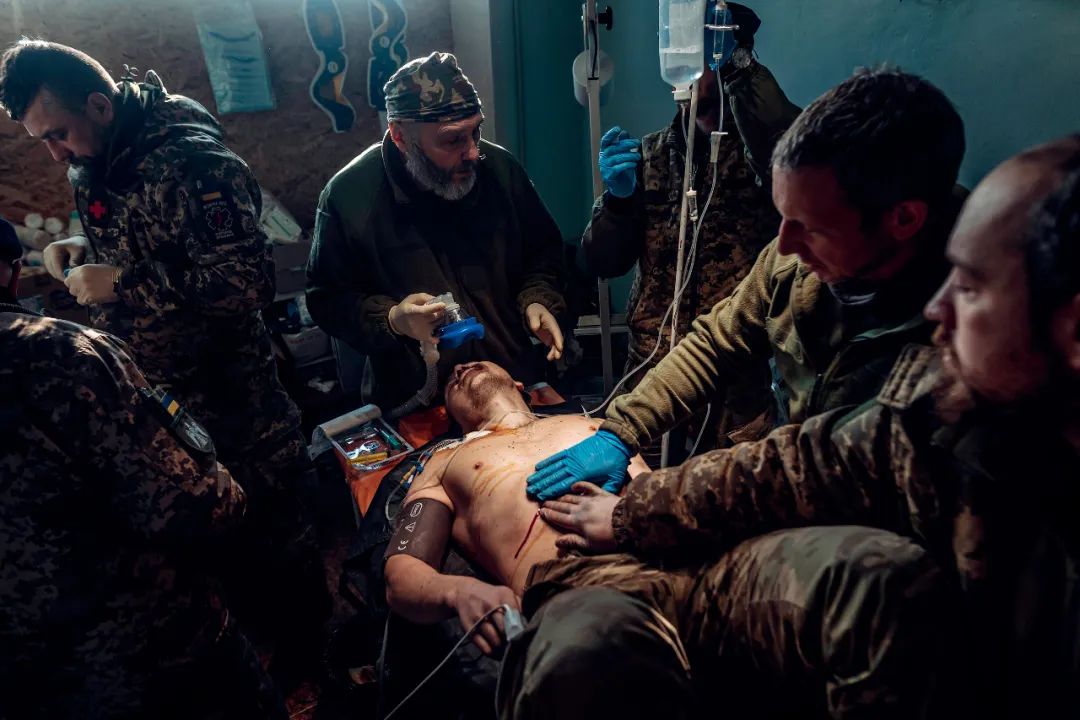 2022年12月25日，顿涅茨克地区巴赫穆特，乌克兰军队医护人员在顿巴斯前线治疗受伤士兵。图/视觉中国