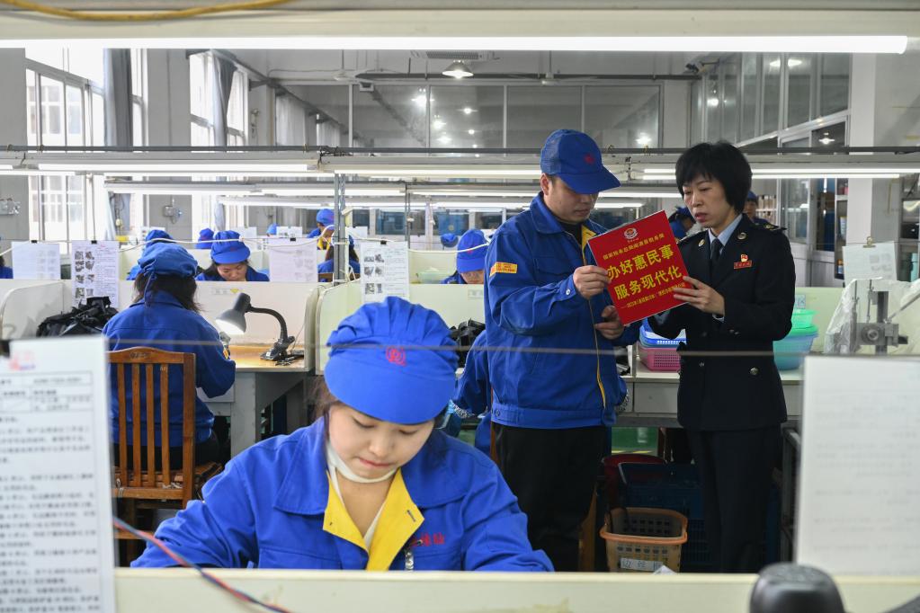 在福州荣清橡胶有限公司生产车间,国家税务总局闽清县税务局工作人员向企业负责人介绍税惠政策。 新华社记者 周义 摄