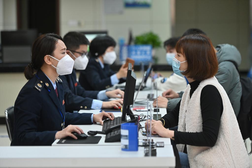 在福州市闽清县办税服务大厅,工作人员向企业工作人员介绍税惠政策。新华社记者 周义 摄