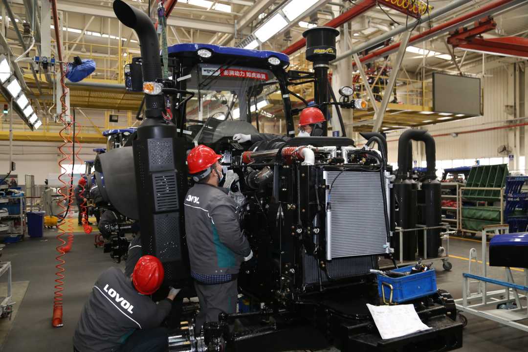 潍柴雷沃重工股份有限公司的车间内，工人在装配拖拉机。（资料图片）