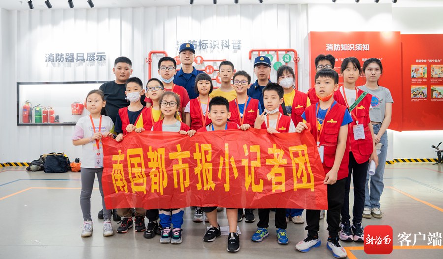 3月26日,南国小记者们走进海口市美兰区图书馆消防体验馆。图为小记者们和消防员合影。记者 李昊 摄
