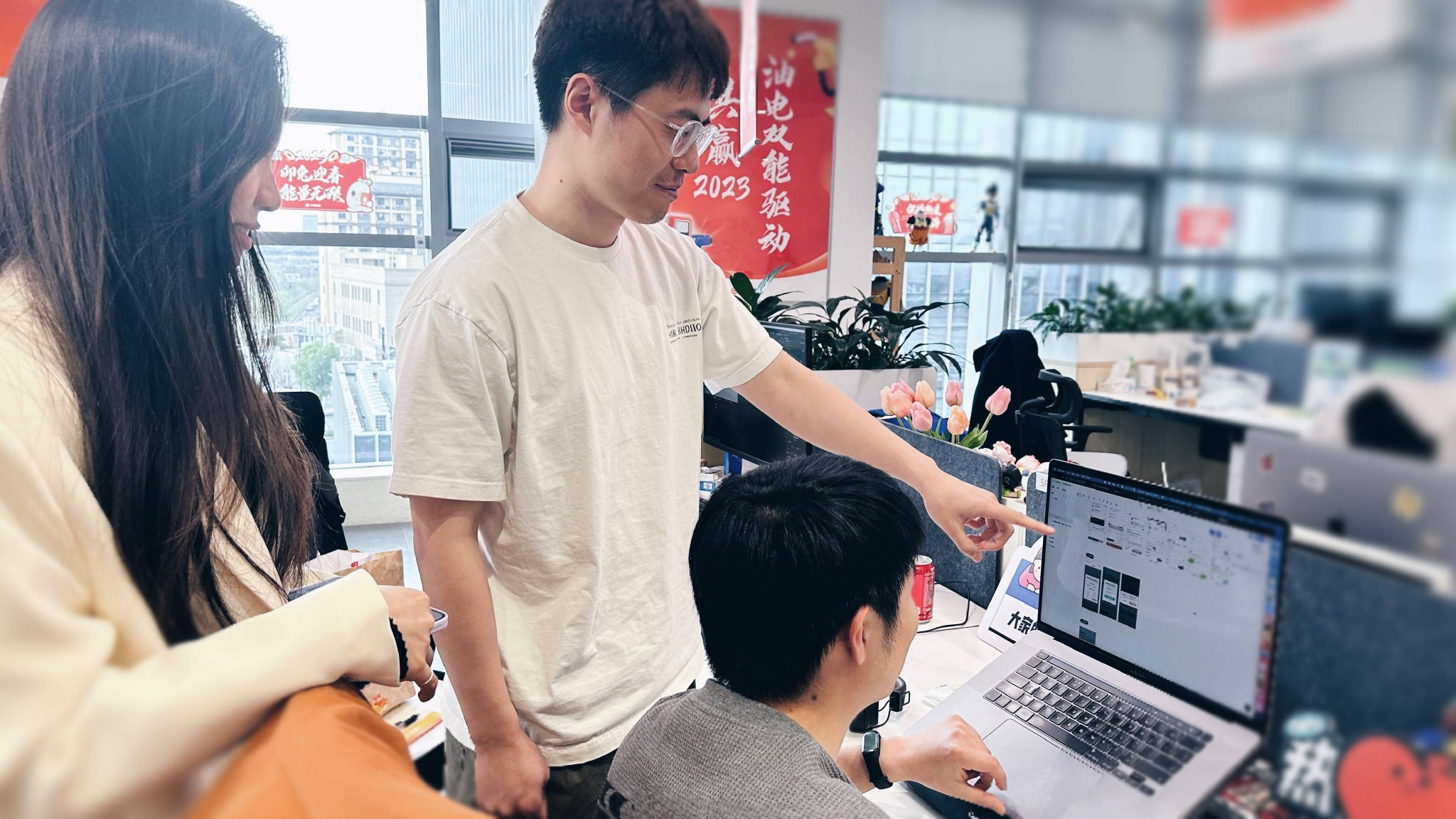 (图:小桔能源设计师讨论MasterGo设计稿)