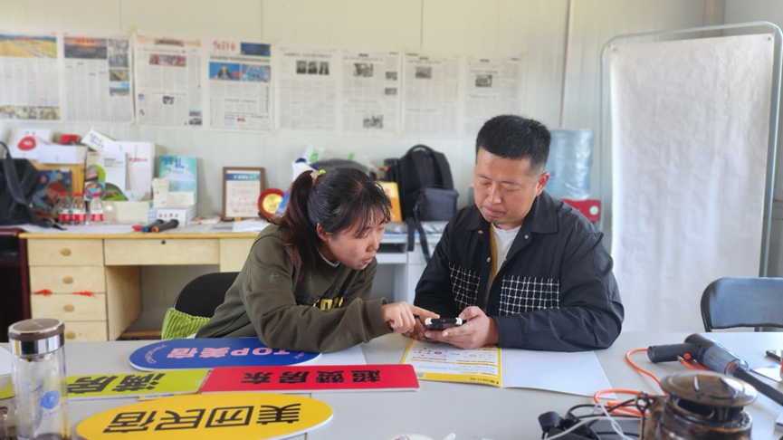 ▲美团民宿销售与刘慧敏交流线上运营,摄影:张希