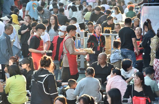 4月30日,在淄博市张店区一家“网红”烧烤店,服务员给顾客上烤串。新华社图