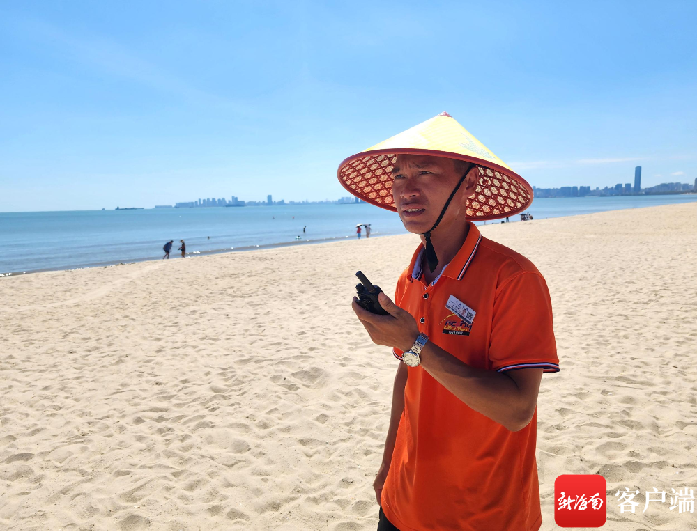 假日海滩工作人员拿着对讲机开始安全巡逻。记者 汪承贤 摄