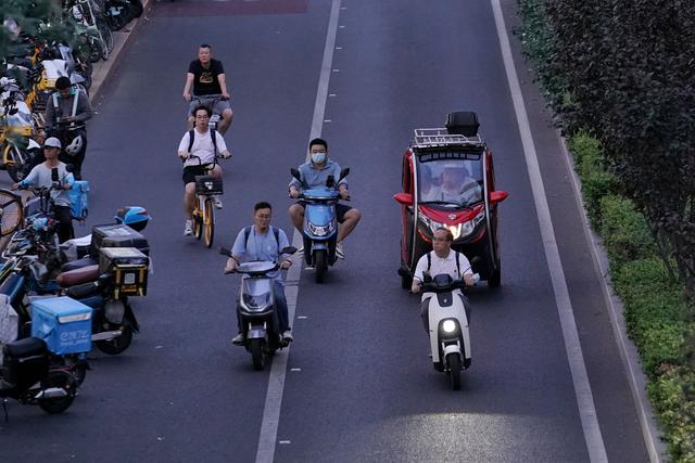 6月30日晚高峰时段，广渠门内大街，未佩戴安全头盔的市民正在骑行电动自行车。新京报记者 王贵彬 摄