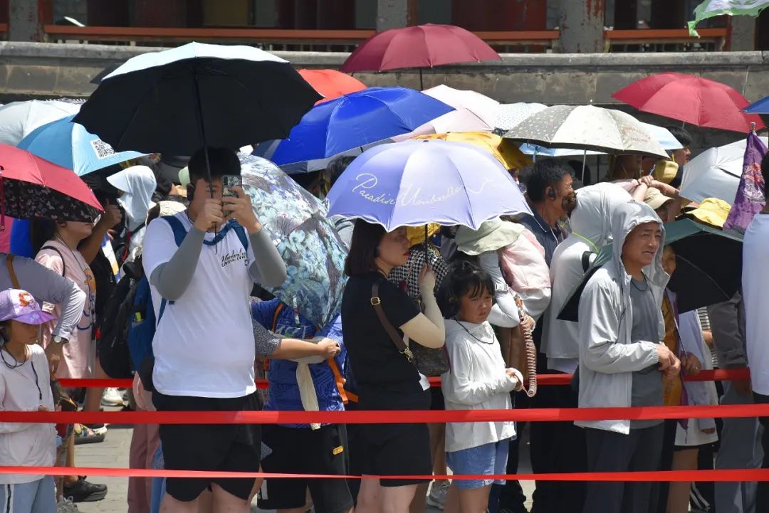 北京热浪翻滚,游客“全副武装”游览颐和园。图片来源:视觉中国