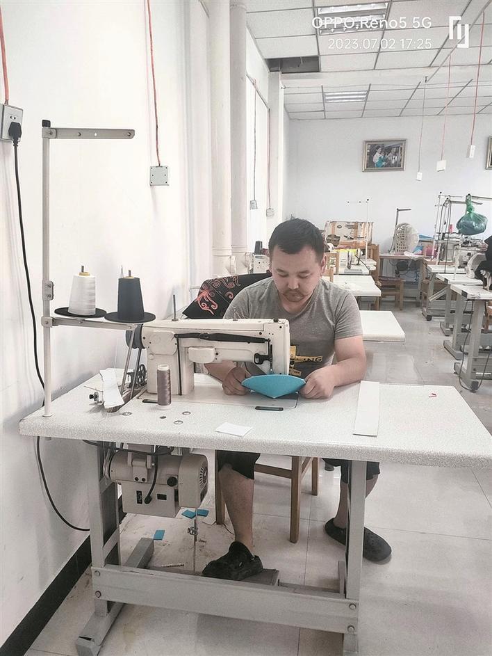 鲁尔登别克·吐尔洪在车间制作手工艺品(资料图片)。古丽米拉·吐尔洪 摄