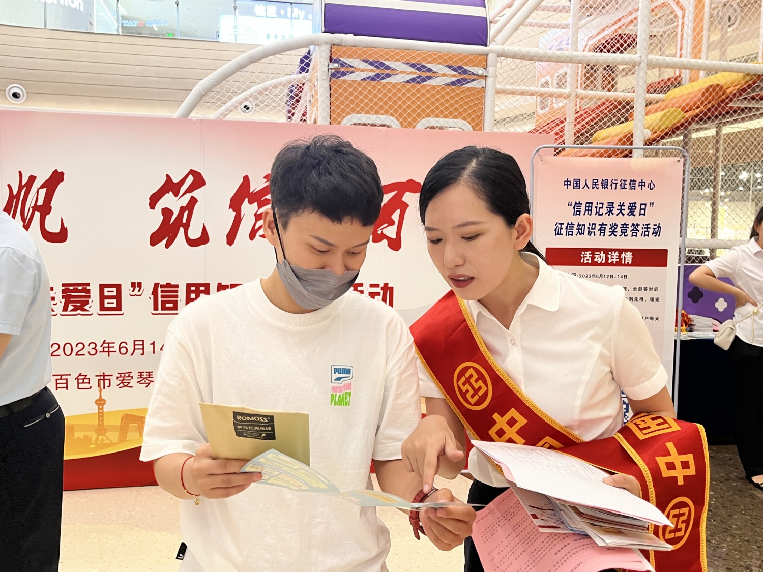 图为工商银行百色分行员工引导群众参加征信知识“猜灯谜”活动。