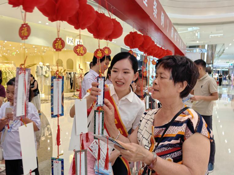图为工商银行百色分行员工向青年群众宣传个人征信查询方式。