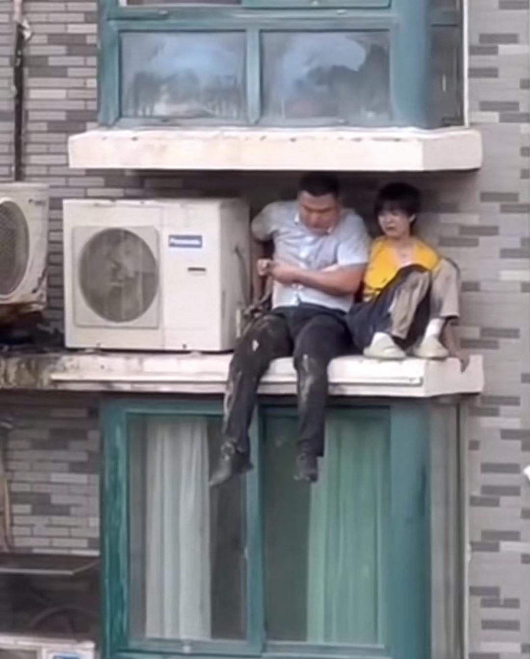 ▲徐亮将孩子转移到空调外机旁 视频截图