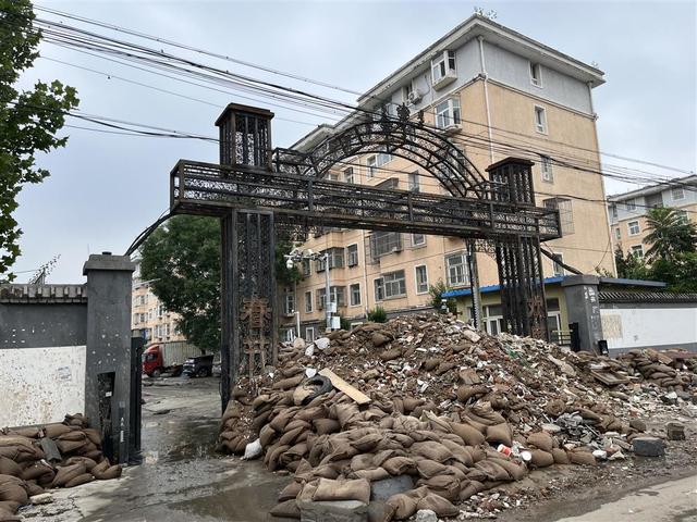 8月2日,小区积水都已经排出,围堵西门的泥沙袋还未撤走。 杨书源 摄
